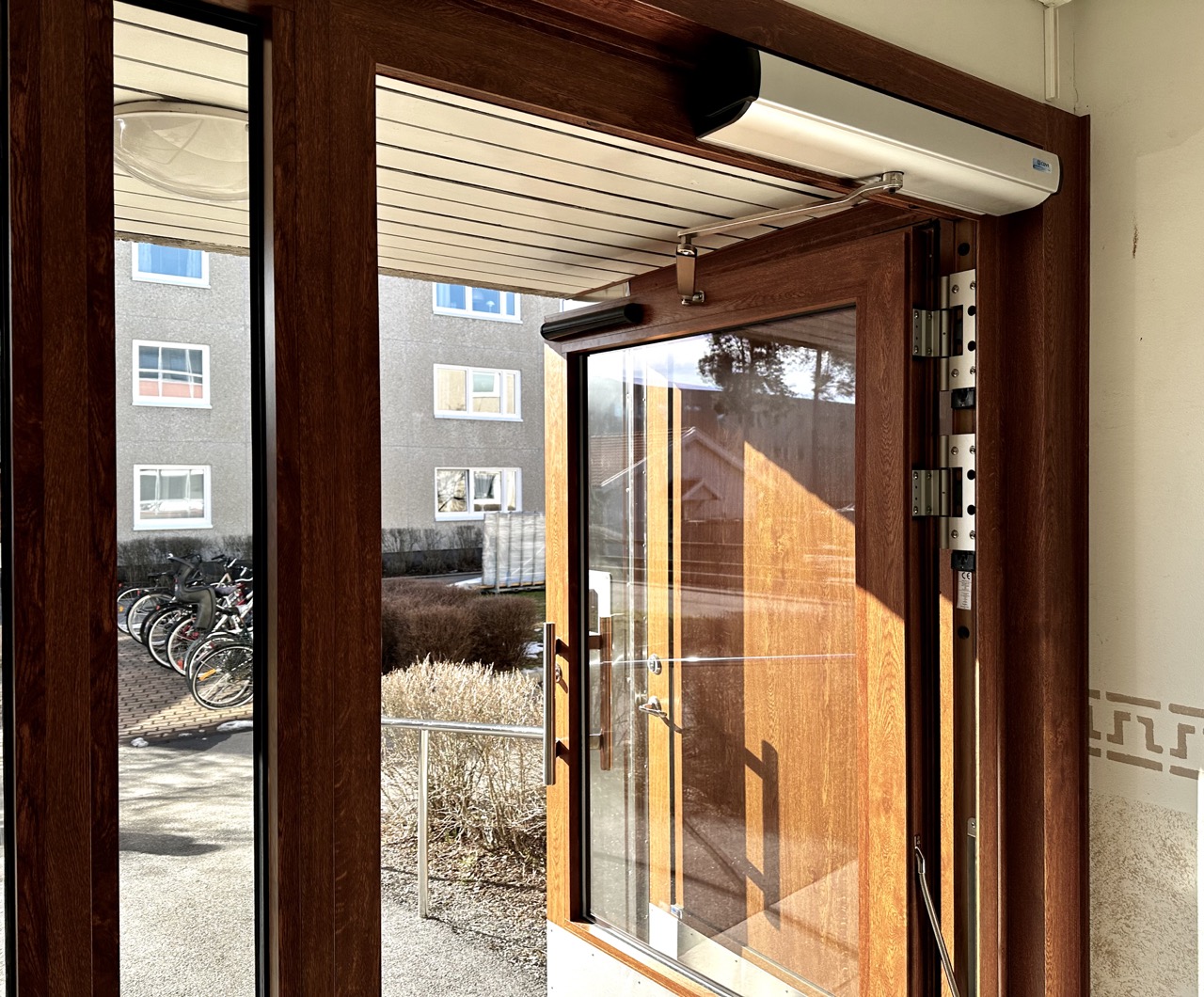 träentrédörr som står öppen med hjälp av dörrautomatik